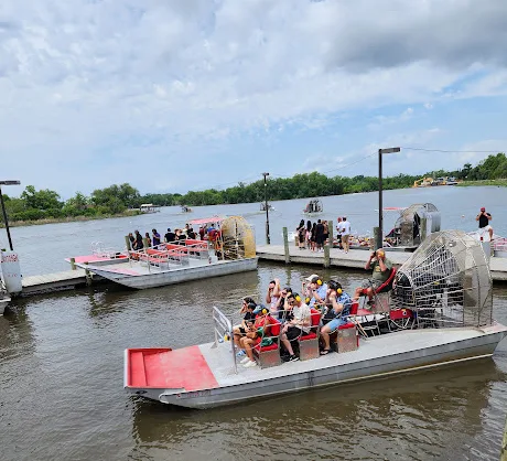 Airboats docked along the bayou at a swamp tour launch near New Orleans