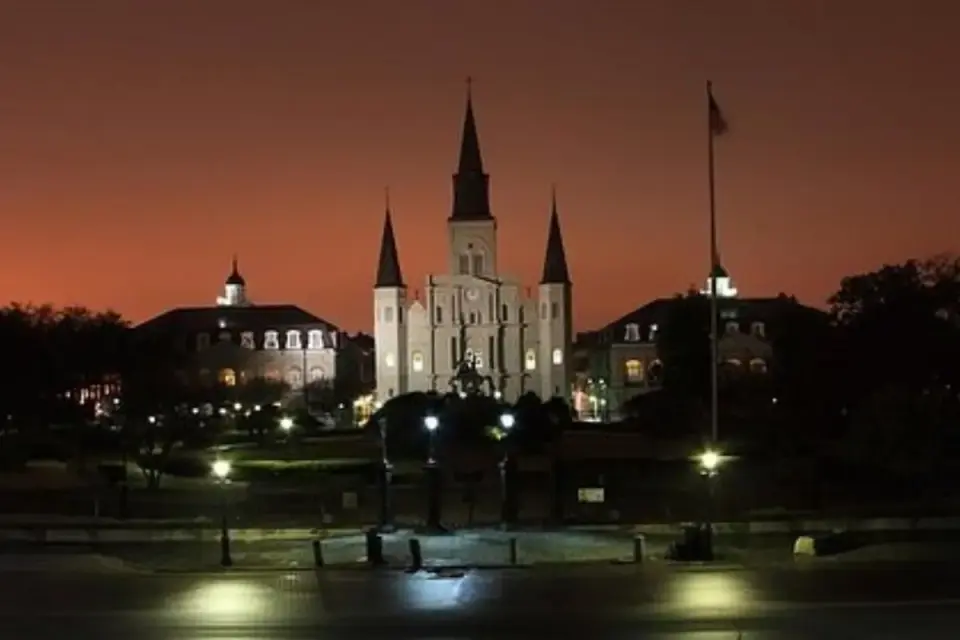 St. Louis Cathedral silhouetted against a fiery dusk sky over Jackson Square